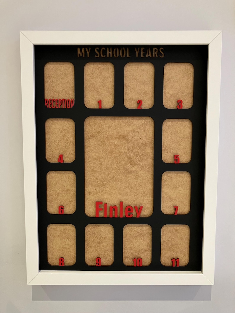 May include: A white rectangular frame containing a black mat with the text MY SCHOOL YEARS at the top. It features twelve small photo slots labeled Reception through 11 in red, plus a large central slot with the red name Finley printed below.