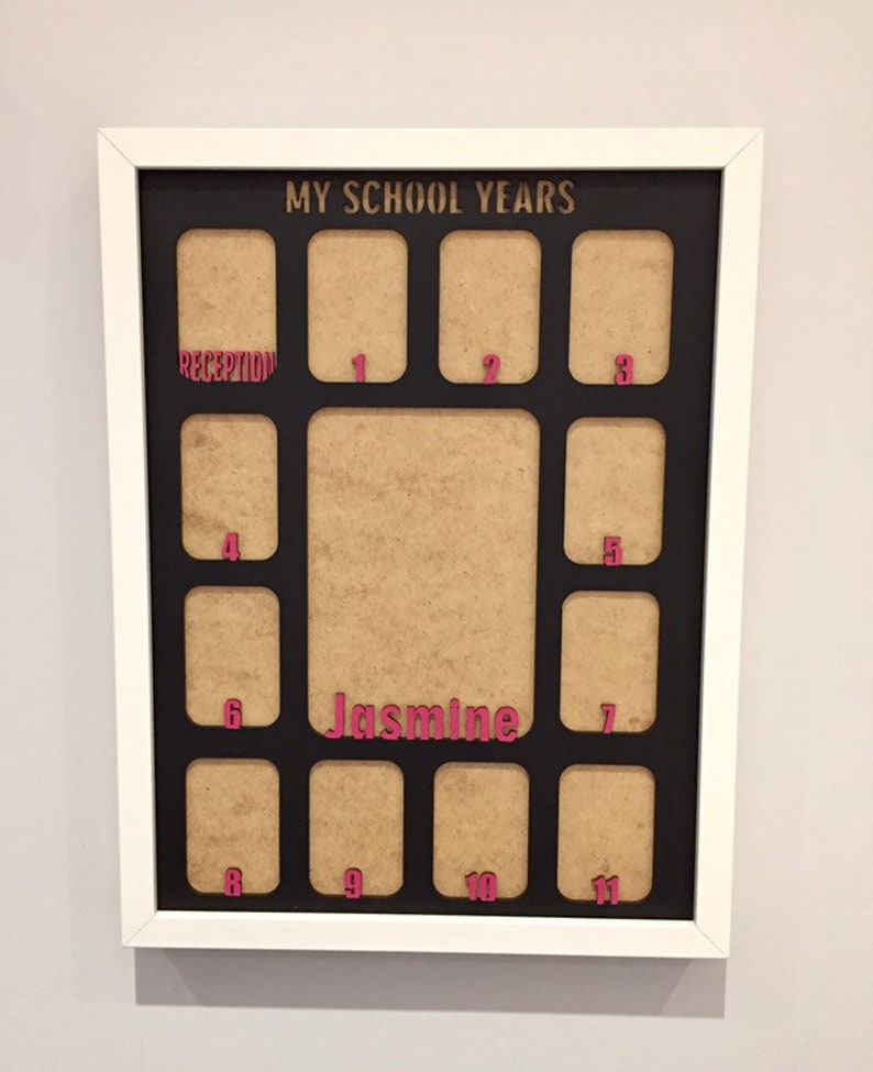 May include: A white framed collage picture frame with a black mat board titled MY SCHOOL YEARS in gold. It features twelve small rectangular openings labeled with pink text for Reception through 11, and a large central opening labeled Jasmine.