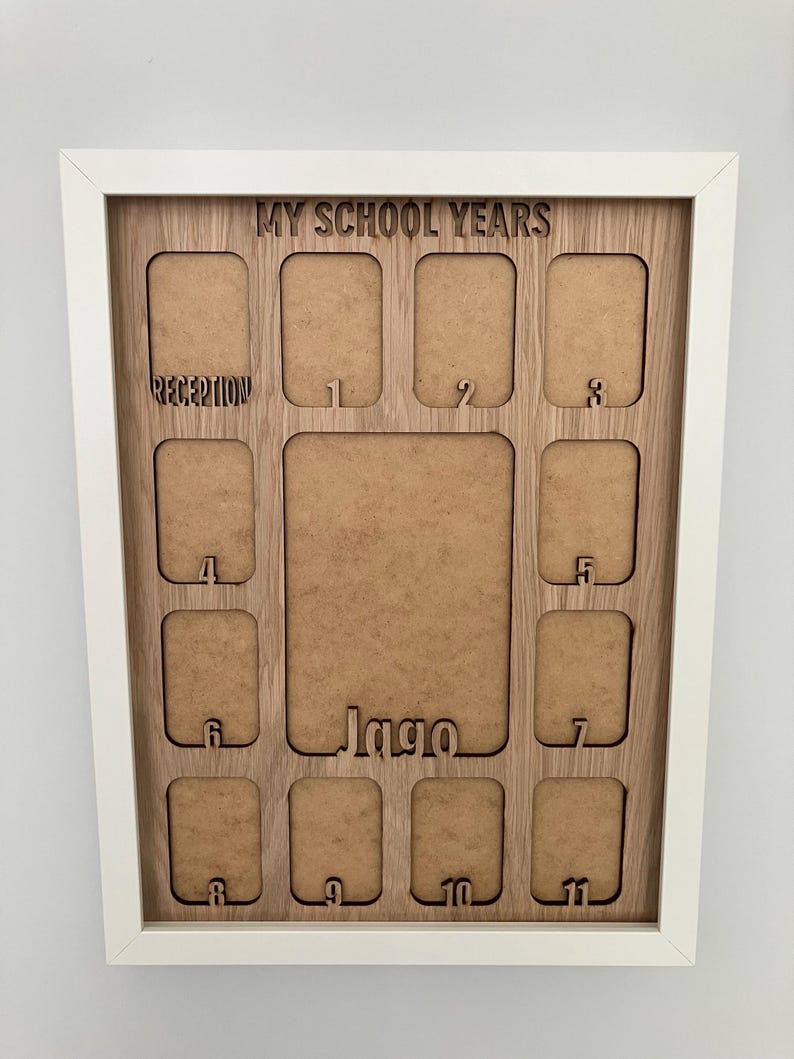 May include: A white-framed wooden photo collage board titled MY SCHOOL YEARS with cutouts for photos labeled RECEPTION, 1 through 11, and a larger central space featuring the name Jago in a cutout script font at the bottom center.