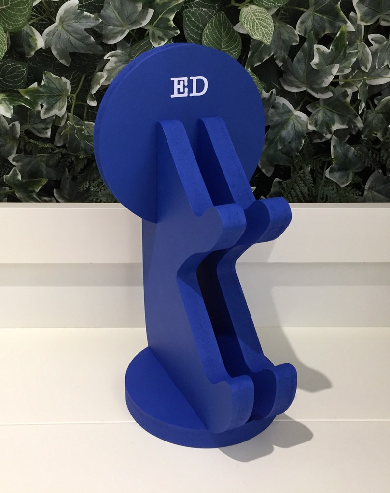 K&ouml;nnte beinhalten: Ein blauer, h&ouml;lzerner Telefonst&auml;nder mit einer runden Oberseite, auf der "ED" in wei&szlig;en Buchstaben steht. Der St&auml;nder hat zwei F&auml;cher f&uuml;r Telefone.