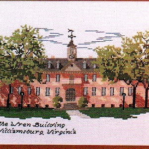 May include: A cross-stitch embroidery of the Wren Building at the College of William & Mary in Williamsburg, Virginia. The building is red brick with white trim and a clock tower. There are two green trees on either side of the building.