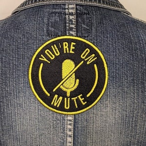 May include: A black and yellow embroidered patch with the text "YOU'RE ON MUTE" and a crossed-out microphone icon.