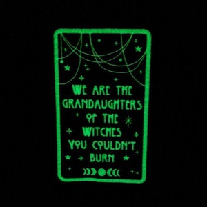 May include: A green glow-in-the-dark patch with the text "We are the granddaughters of the witches you couldn't burn" and a crescent moon design.