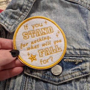 May include: White embroidered patch with yellow stitching. The patch says "If you stand for nothing, what will you fall for?" with a small star in the centre.