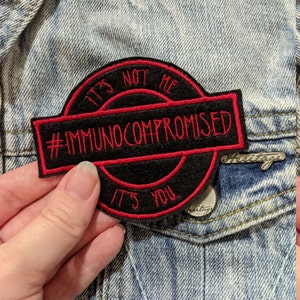 May include: Black and red embroidered patch with the text "It's not me #immunocompromised It's you".