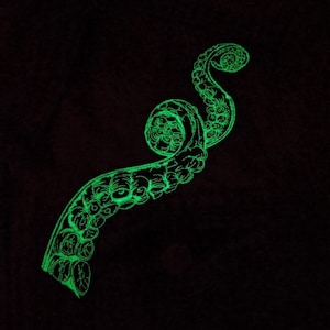 May include: A glowing green octopus tentacle design on a black background. The tentacle is curled and detailed with suction cups.