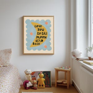 May include: A framed art print with the text "Love you to the moon and back." The artwork features a yellow crescent moon, blue cloud-like shapes, and orange stars on a cream background. The frame is a light brown color.