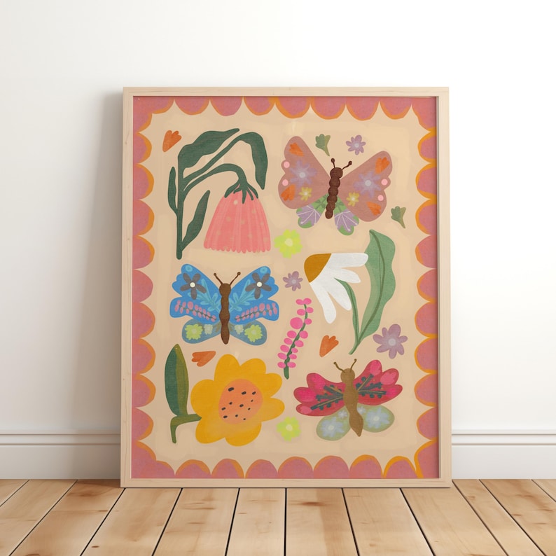 May include: A framed art print with a colourful floral and butterfly design. The artwork features butterflies, flowers, and foliage on a beige background, framed with a pink scalloped border and a natural wood frame.