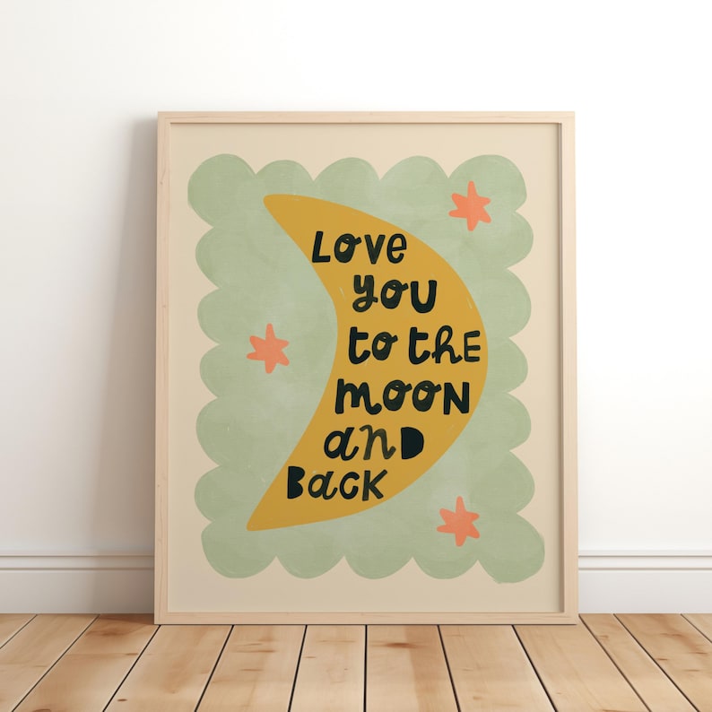May include: A framed art print with the words "Love you to the moon and back" in black text. The design features a yellow crescent moon, orange stars, and a green scalloped border on a cream background.