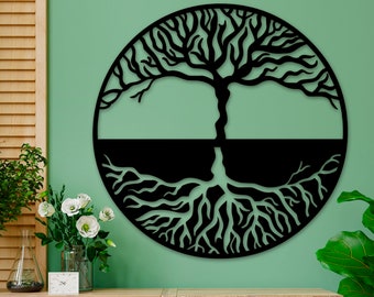 Könnte beinhalten: Schwarze Wandkunst aus Metall, die einen Lebensbaum mit filigranen Ästen und Wurzeln darstellt. Der Baum ist vor einem grünen Hintergrund platziert.