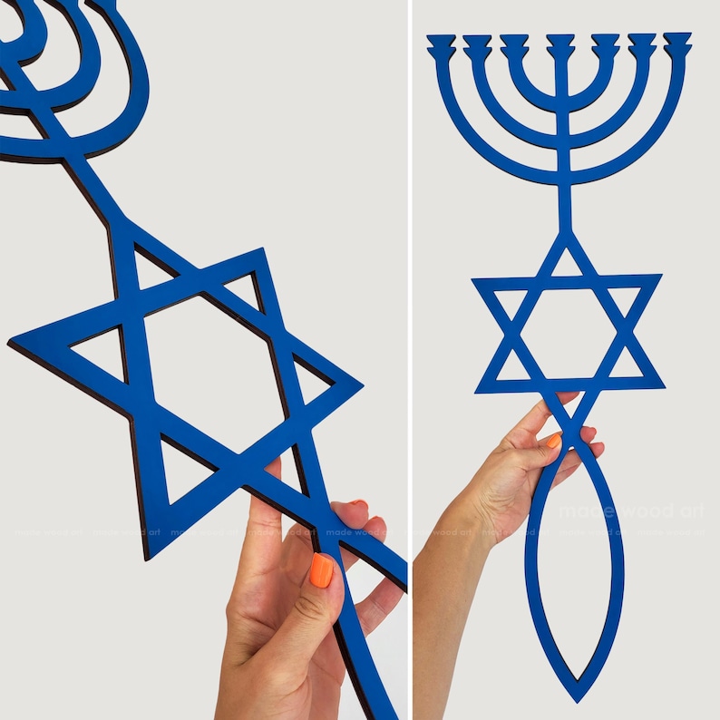 May include: Blue wooden Star of David and menorah wall art. The Star of David is a six-pointed star, and the menorah has seven candle holders. The art is held by a person with orange nail polish.
