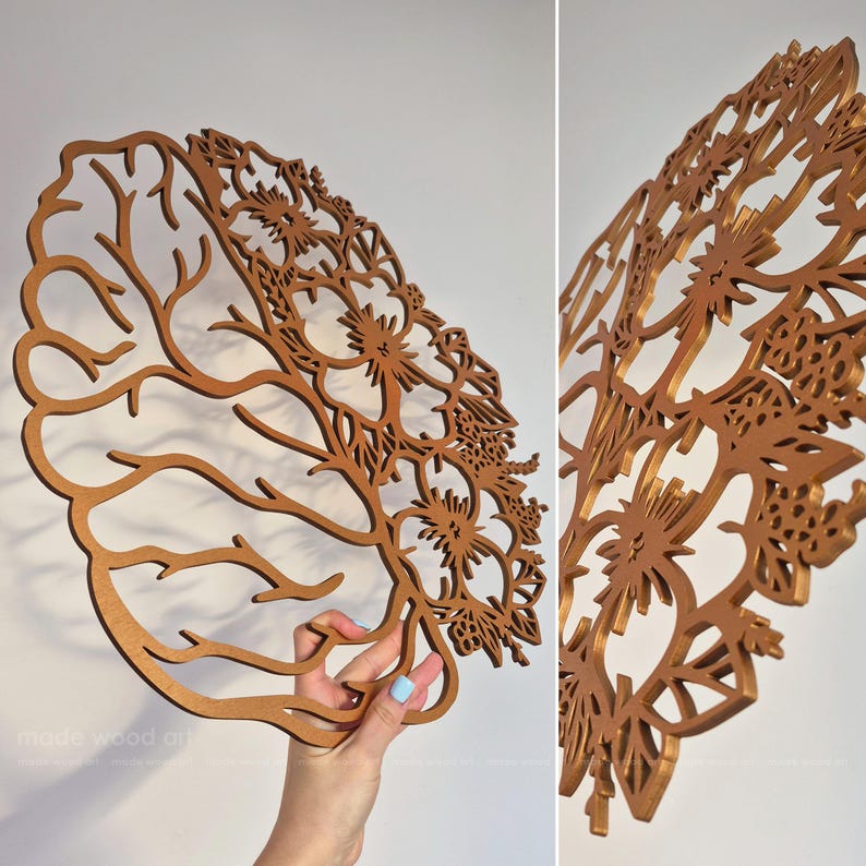 May include: A circular, laser-cut wooden wall art piece featuring a split design. One half displays a detailed anatomical brain structure with branching neural pathways, while the other half showcases intricate floral patterns and blooming flowers.