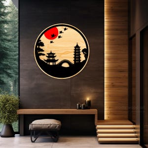 May include: A round wooden wall decor with a black silhouette of a Japanese pagoda, bridge, and trees. The sun is a red circle with birds flying around it.