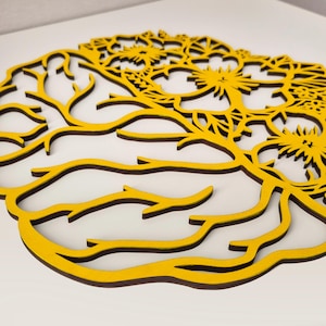 May include: A yellow laser-cut wall art piece shaped like a human brain. The left side features branching, root-like lines, while the right side transitions into a detailed floral pattern with multiple flower blossoms integrated into the design.