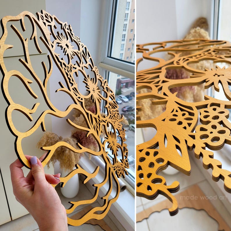 May include: A circular wooden wall art piece featuring an intricate laser-cut design of a brain silhouette integrated with floral and botanical patterns. The natural wood finish displays a warm golden-brown tone with detailed cutouts.