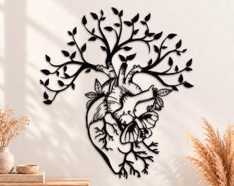 May include: A black metal wall art piece featuring an anatomical heart shape that transitions into a tree with spreading branches and leaves at the top. A butterfly is positioned on the side of the heart, which also has root-like structures.