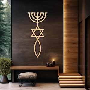May include: A wooden wall art piece featuring a menorah, Star of David, and fish symbol. The artwork is a light brown color and is mounted on a dark gray wall. The scene includes a bench, stool, and candles.