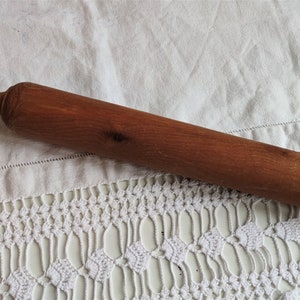 Può includere: Un mattarello di legno con un manico leggermente arrotondato. Il mattarello è marrone e ha una finitura in legno naturale.