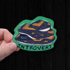 May include: A distressed wooden sign with the words "Welcome to our home" in white lettering. The sign has a rustic finish, ideal for a front porch or hallway, creating a welcoming atmosphere.