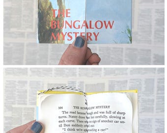 May include: A vintage Nancy Drew mystery book titled "The Bungalow Mystery" with a yellow spine and blue cover. The book is open to page 164 and shows a scene from the story.