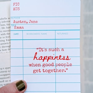 May include: A white library card with blue lines and red text. The card has the title "Emma" by Jane Austen. The quote "It's such a happiness when good people get together." is printed in red.