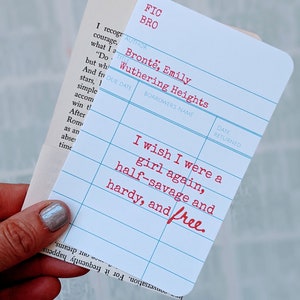Puede incluir: Una tarjeta de biblioteca azul y blanca con el texto "FIC BRO" en rojo en la parte superior. La tarjeta tiene el t&iacute;tulo "Wuthering Heights" de Emily Bronte. El texto "I wish I were a girl again, half-savage and hardy, and free." est&aacute; escrito en rojo en la tarjeta.