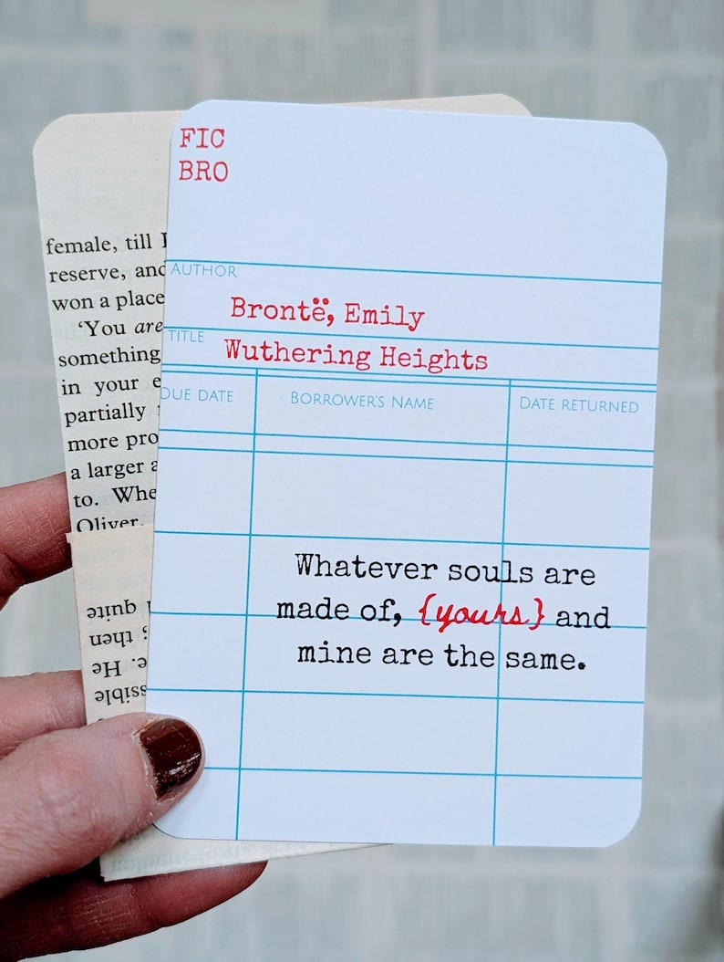 May include: A white card with blue grid lines and red text, resembling a library card, features the title "Wuthering Heights" by Emily Bront&euml;. The quote "Whatever souls are made of, {yours} and mine are the same" is printed on the card.