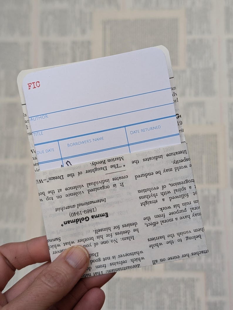 May include: A white library card with blue lines. The card has the word "FIC" in red at the top. The card has fields for "Author", "Title", "Due Date", "Borrower's Name", and "Date Returned".