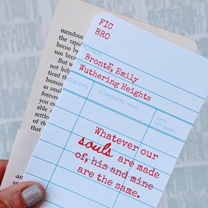 Puede incluir: Una tarjeta de biblioteca azul y blanca con el t&iacute;tulo "Cumbres Borrascosas" de Emily Bront&euml;. La tarjeta tiene una cita del libro: "Whatever our souls are made of, his and mine are the same."