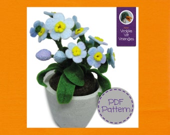 Op de afbeelding: Een vilten bloemstuk in een grijze pot. De bloemen hebben lichtblauwe bloemblaadjes en gele centra. Groene bladeren en knoppen zijn ook zichtbaar. De afbeelding bevat de tekst "PDF Pattern" en "Vrolijke Vilt Vriendjes".