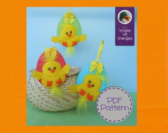 Op de afbeelding: Drie vilten paaseieren met gele kuikens erin. De eieren zijn groen, roze en blauw. De ornamenten hangen aan een touwtje en staan voor een rieten mand. De tekst "PDF Pattern" staat op een paarse cirkel in de rechterbenedenhoek. De tekst "Vrolijke Vilt Vriendjes" staat op een paarse rechthoek in de rechterbovenhoek.