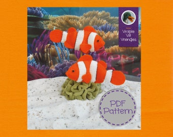 Op de afbeelding: PDF-patroon voor twee viltclownvissen. De vissen zijn oranje en wit met zwarte strepen. Het patroon is voor een knutselproject.
