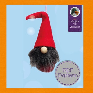 May include: A handmade gnome ornament with a red pointed hat, gray beard, and a wooden nose. The gnome is suspended against a light blue background. The image also includes a PDF pattern label.