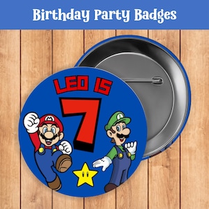 May include: Blue birthday party badges featuring Mario and Luigi characters. The badge says "Leo is 7" in red and white text. A yellow star is also featured. The text "Birthday Party Badges" is at the top.
