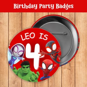 May include: Red birthday party badge with the text "LEO IS 4" and illustrations of Spider-Man, Hulk, and other comic book characters. The badge is round with a pin back.
