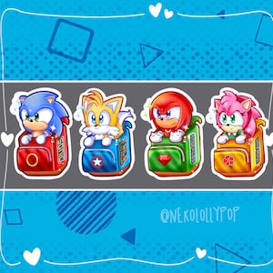 May include: Four cartoon characters from the Sonic the Hedgehog franchise are depicted as stickers. Each character is wearing a backpack with their name on it. Sonic is wearing a red backpack, Tails is wearing a blue backpack, Knuckles is wearing a green backpack, and Amy is wearing a yellow backpack.