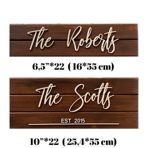 May include: Two wooden signs with the names "The Roberts" and "The Scotts EST 2015" in cursive script. The signs are 6.5 inches by 22 inches and 10 inches by 22 inches.