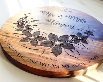 May include: A round wooden serving board with an engraved floral design and the text "Mr & Mrs Timani", "FIJI 29.12.2018", and "I have found the one whom my soul loves Song of Solomon 3:4".