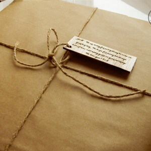K&ouml;nnte beinhalten: Ein braunes Papierpaket, das mit Schnur gebunden ist und einen Holzetikett mit der Aufschrift "Wir waren wirklich begeistert, dich dieses Jahr kennenzulernen. Wir hoffen auf viele weitere Dinge, die wir teilen k&ouml;nnen, und viele weitere Geschenke in deiner Zukunft. Wir lieben dich! S & J" tr&auml;gt.