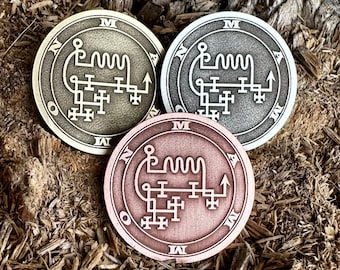 May include: Three metal tokens with sigils inscribed on them. The tokens are in gold, silver, and copper.