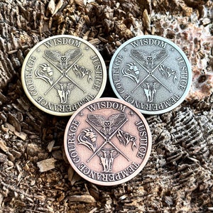 Puede incluir: Tres fichas metálicas redondas con un diseño de búho, león, elefante y tigre. Las fichas están inscritas con las palabras "Sabiduría", "Justicia", "Templanza" y "Valor".