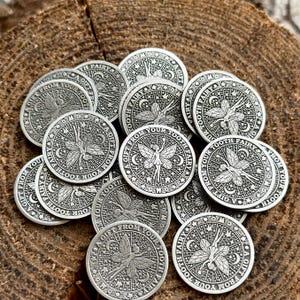May include: A pile of silver-colored tooth fairy coins with the inscription "A Gift From Your Tooth Fairy" on each coin.