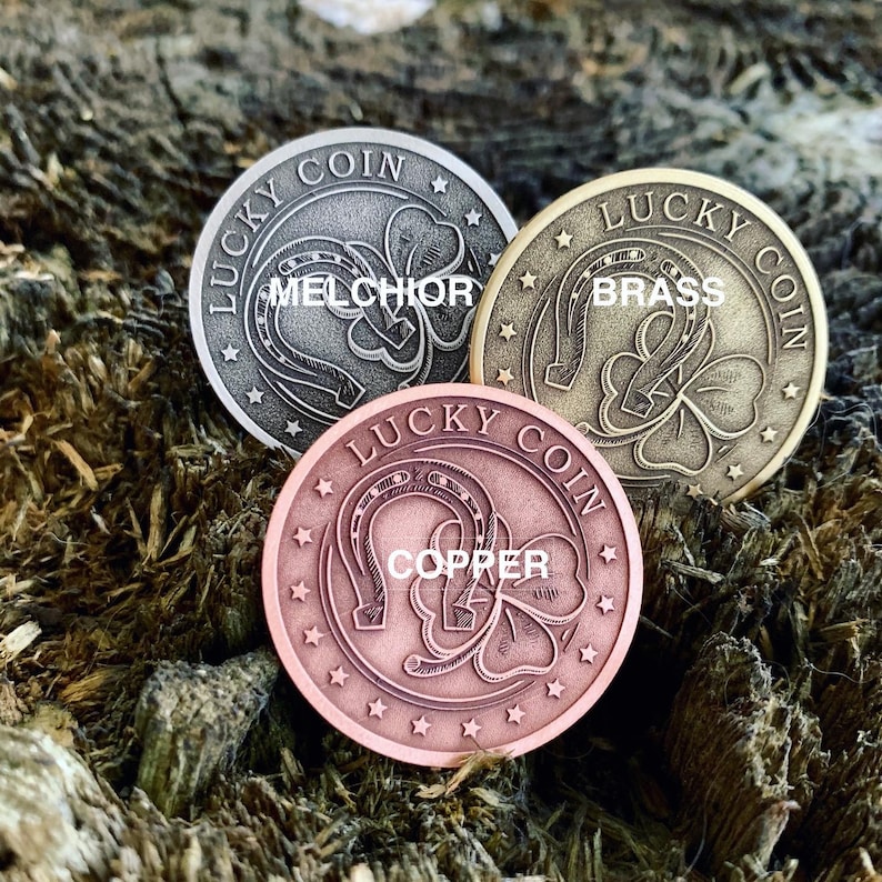 May include: Three lucky coins with a horseshoe and shamrock design. The coins are made of different metals: melchor, brass, and copper. Each coin has the words "Lucky Coin" inscribed around the edge.