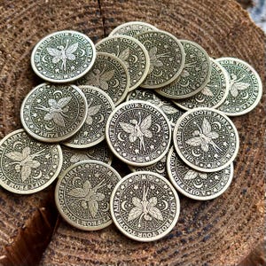May include: A collection of gold-colored metal tokens with a fairy design and the text "A Gift From Your Tooth Fairy".
