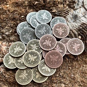 May include: A collection of silver, gold, and copper-toned metal tokens with a fairy design and the text "A Gift From Your Tooth Fairy".