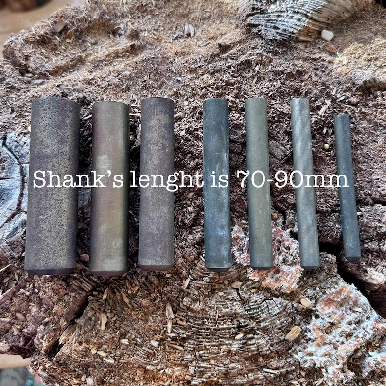 May include: An assortment of cylindrical metal objects in varying shades of gray and brown, arranged on a textured wooden surface. The text "Shank's lenght is 70-90mm" is visible. The objects appear to be components or parts.