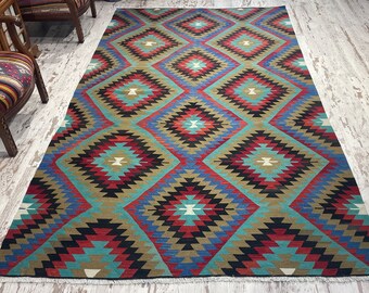 May include: A colorful rug with a geometric pattern in shades of red, blue, green, and black. The rug has a diamond-shaped design with a central star.