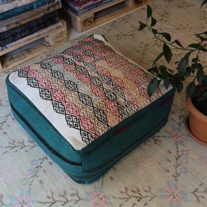 Puf vintage em tapete Kilim, otomano quadrado turquesa e branco.