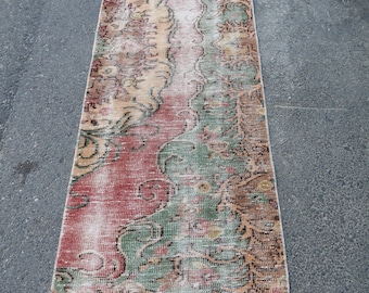 Könnte beinhalten: Ein Vintage-Läufer mit einem verblassten Blumenmuster in Rot-, Grün- und Beigetönen. Der Teppich hat einen Fransenrand und ist aus Wolle.