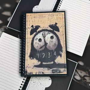 May include: A spiral-bound notebook with a black cover featuring a whimsical clock design. The clock face is stylized with owl-like features, and the background has a vintage newspaper print. Additional notebooks with lined pages are visible.
